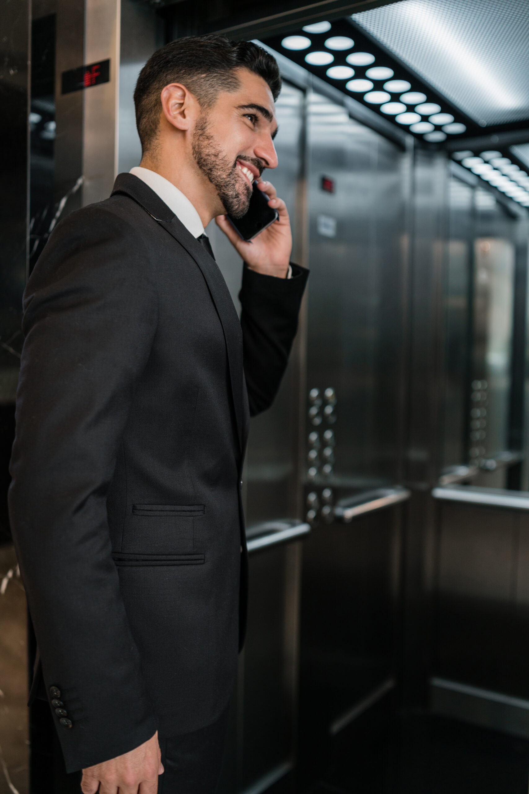 Businessman talking on phone at hotel elevator.
